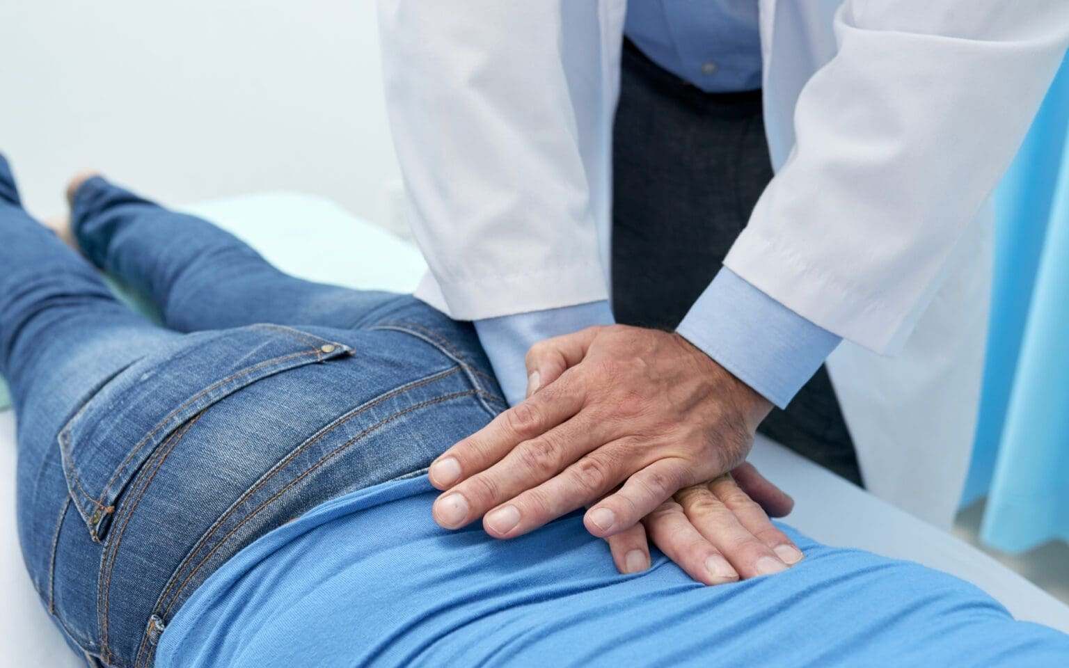 Chiropractor adjusting a patient's back on a treatment table