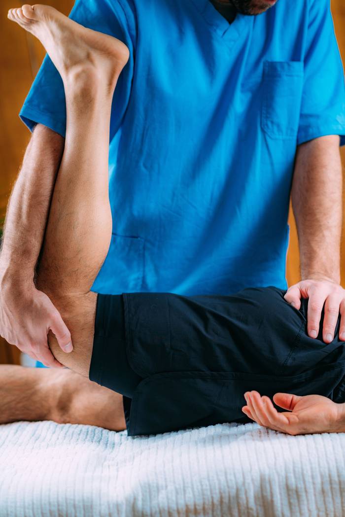 Therapist working on a patient's leg during physical therapy