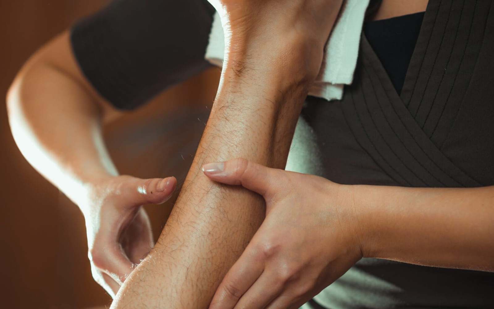 Therapist giving a sports massage to a patient's legs